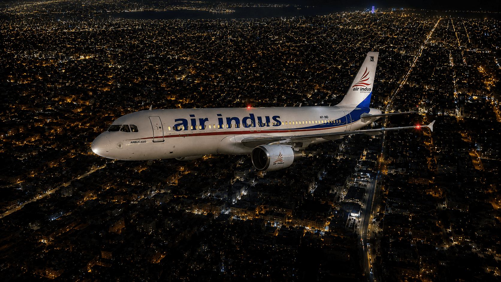 An Air Indus aircraft flying over a city at night